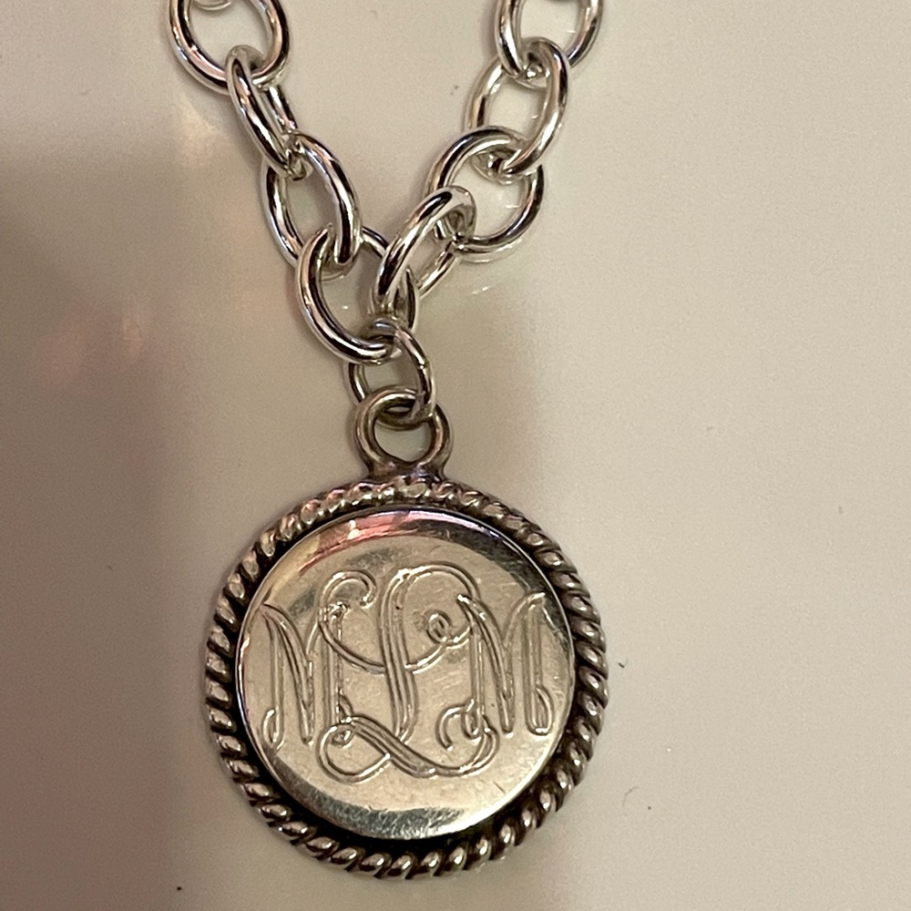 Monogrammed sterling silver pendant.  Initials “MLM” or “MML”.